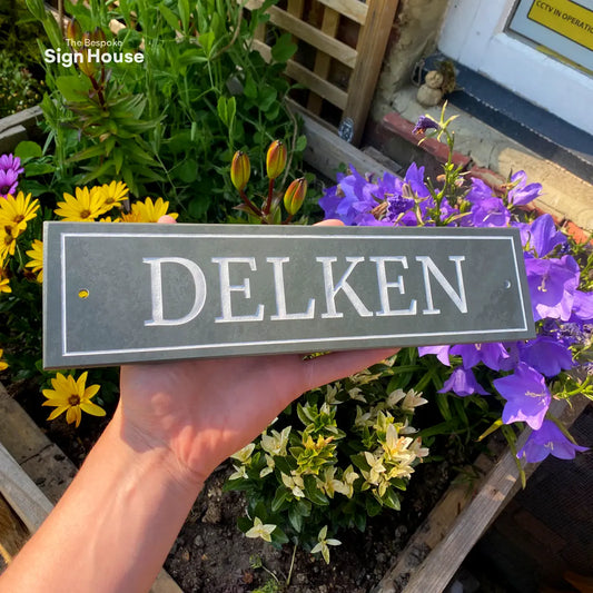 a beautiful grey slate sign for a home doorway, with the house name Delken engraved in white using a traditional style font