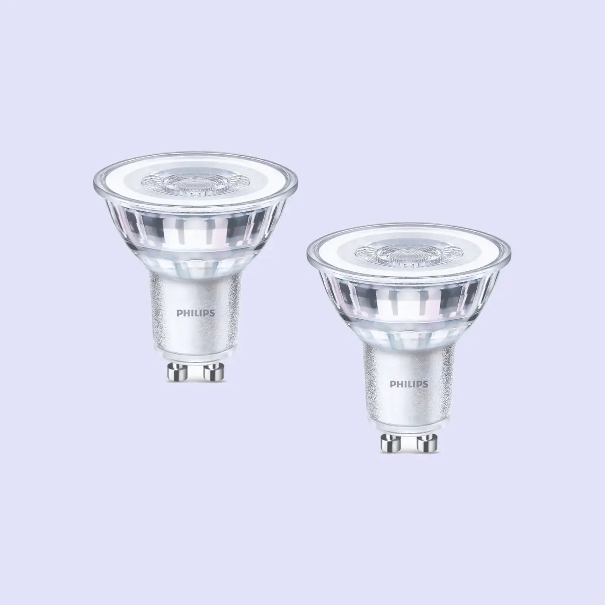 The image shows two Philips GU10 light bulbs with a clear, slightly reflective surface. These LED bulbs have a compact, spotlight-style design with a base featuring two small pins for easy installation. Their sleek and modern appearance suggests energy efficiency and bright, focused lighting.