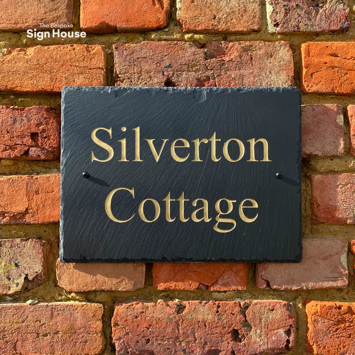 a chiselled welsh slate house sign with house name engraved in gold 